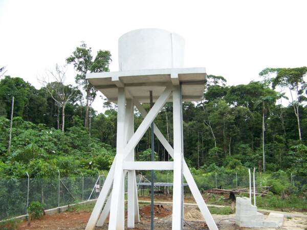 Tanque de almacenamiento del agua - en le fondo los paneles solares